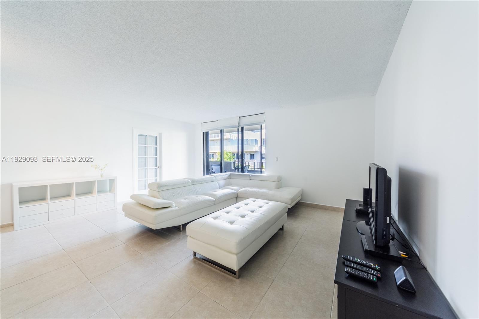 121 Crandon Boulevard, Unit 248 Key Biscayne, FL 33149 - Photo 7 of 37 a living room with furniture and a floor to ceiling window