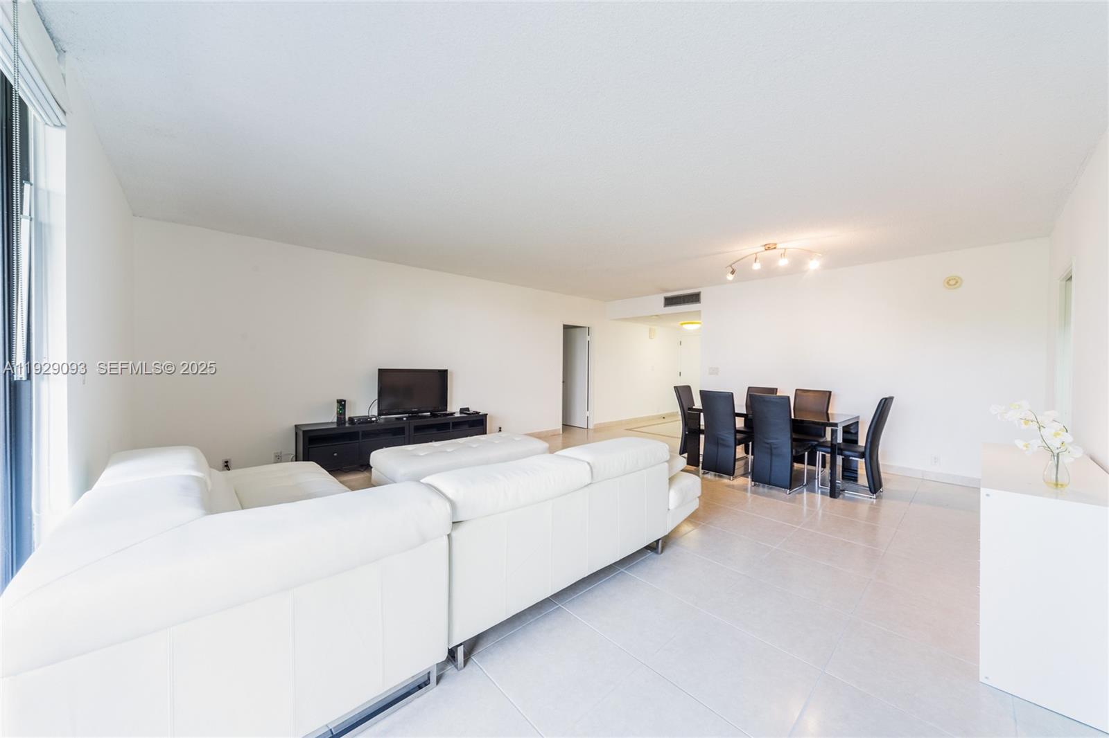 121 Crandon Boulevard, Unit 248 Key Biscayne, FL 33149 - Photo 10 of 37 a living room with furniture and a dining table with wooden floor