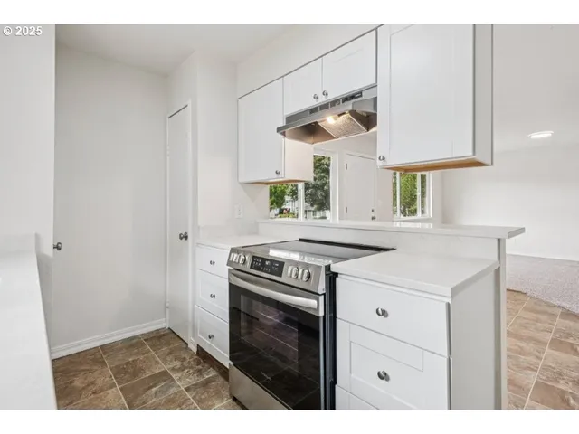 a kitchen with a sink cabinets and wooden floor