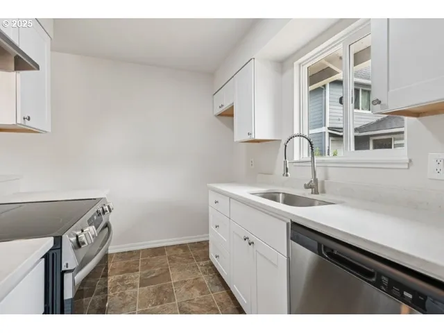 a kitchen with a stove cabinets and wooden floor