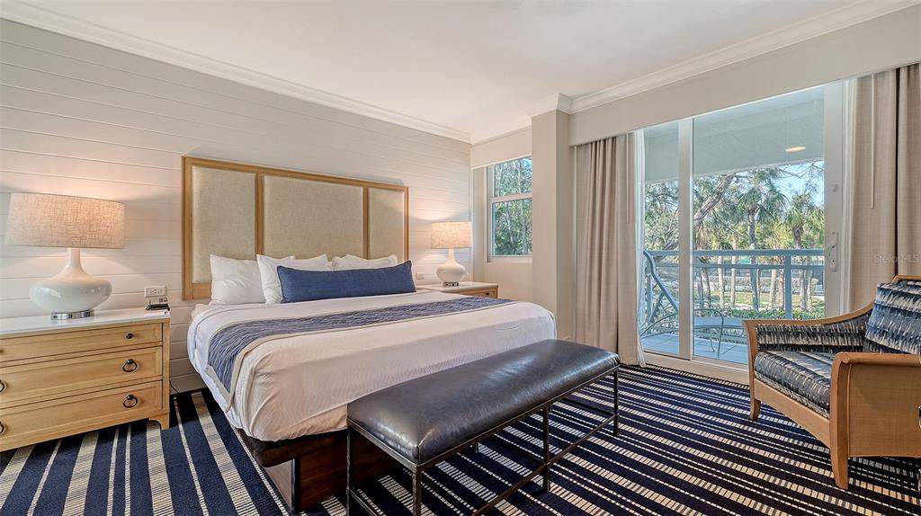 250 Sands Point Road, Unit 5101 Longboat Key, FL 34228 - Photo 11 of 42 a bedroom with a bed and wooden floor