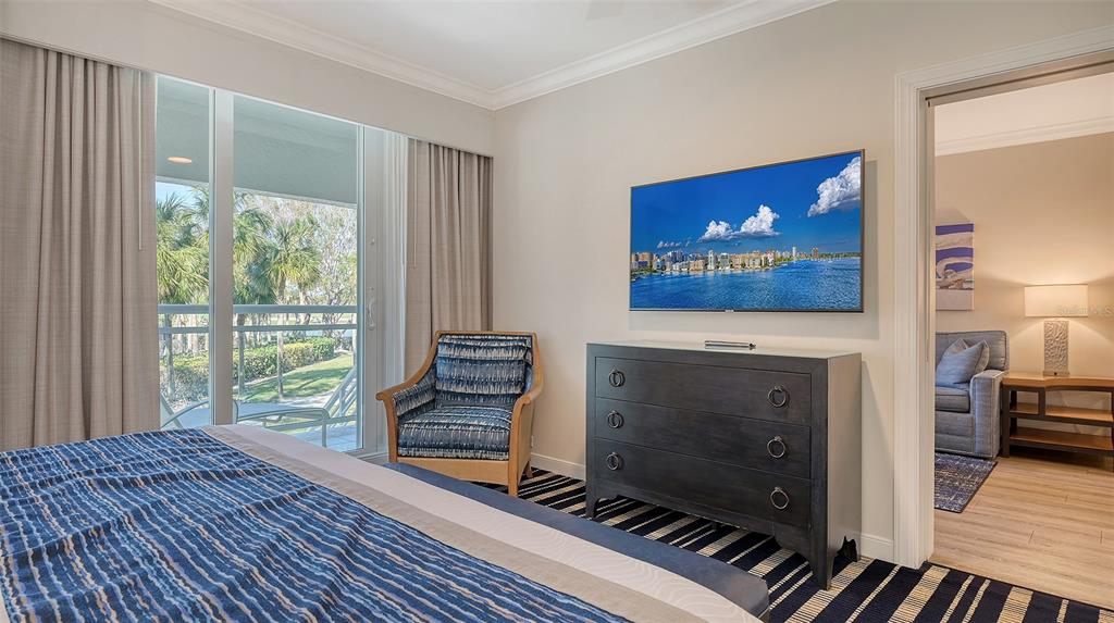 250 Sands Point Road, Unit 5101 Longboat Key, FL 34228 - Photo 12 of 42 a living room with furniture a flat screen tv and a floor to ceiling window