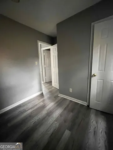 an empty room with wooden floor and closet