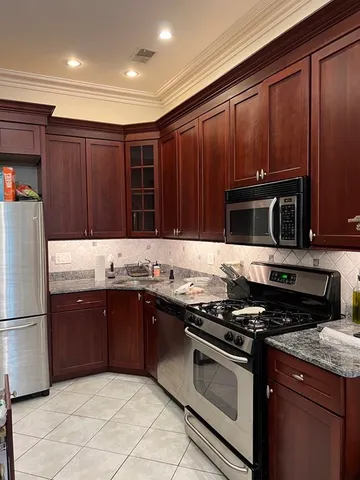 a kitchen with granite countertop stainless steel appliances and wooden cabinets