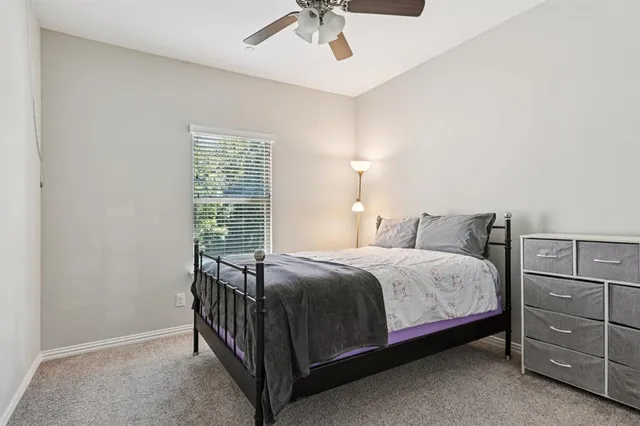 a bedroom with a bed and a ceiling fan