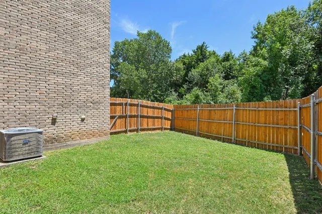 a view of backyard with wooden fence
