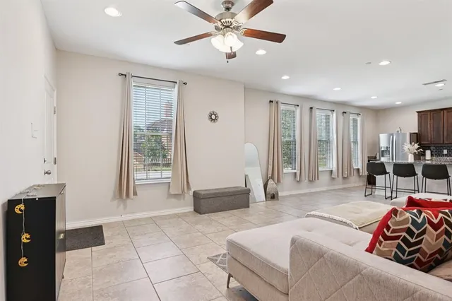 a living room with furniture and a large window with kitchen view