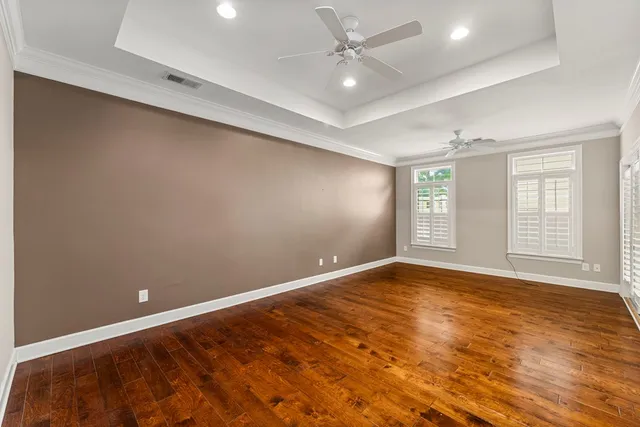 an empty room with windows and fan