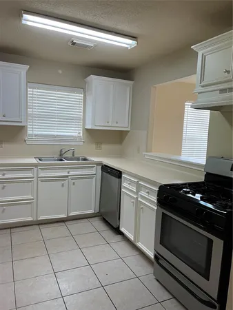 a kitchen with cabinets appliances and a window