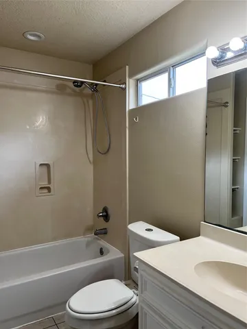 a white toilet and tub next to a bathroom sink