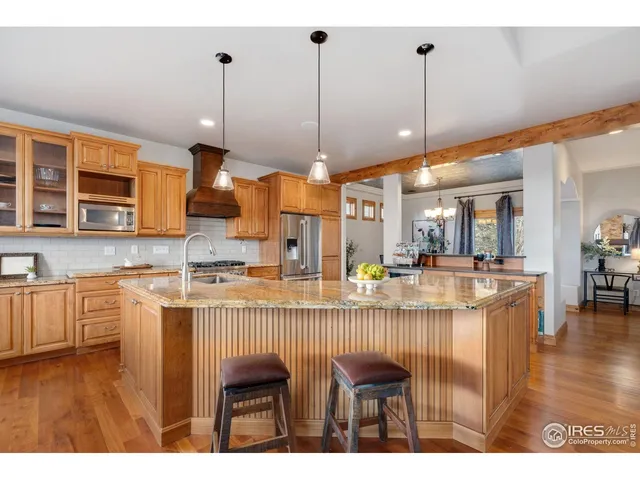 a kitchen with stainless steel appliances granite countertop wooden floor sink and stove