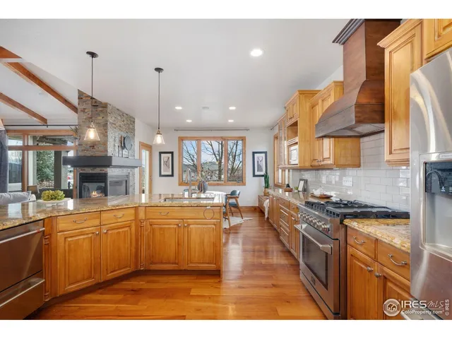 a large kitchen with stainless steel appliances granite countertop a sink and cabinets