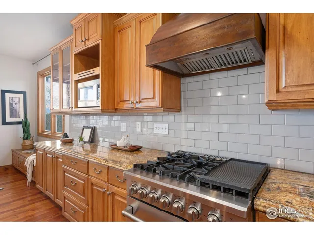 a kitchen with granite countertop a stove a sink dishwasher and cabinets