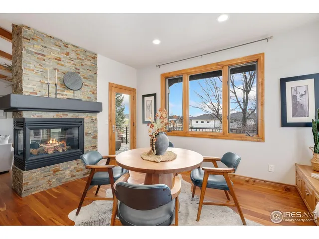 a dining room with furniture a fireplace and wooden floor