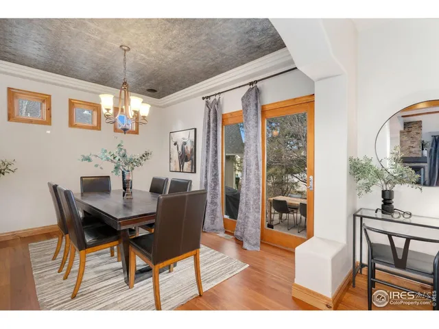 a dining room with furniture a chandelier and wooden floor