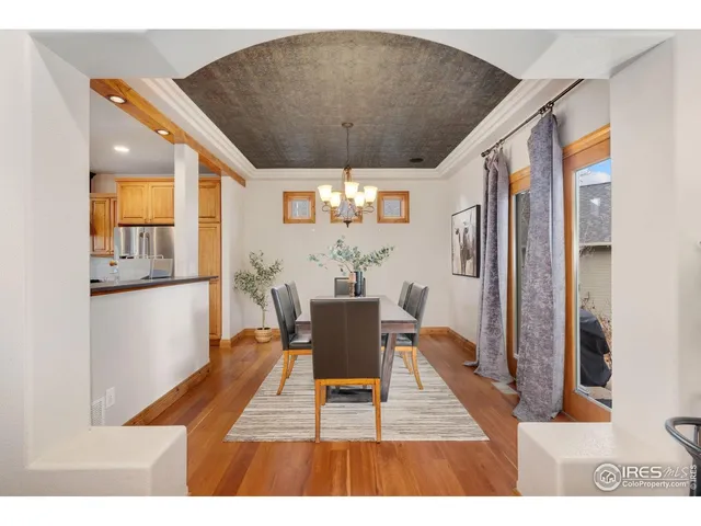 a dining room with wooden floor and a chandelier