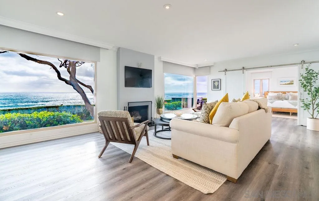 6529 Neptune Place La Jolla, CA 92037 - Photo 2 of 24 a living room with furniture a fireplace and a flat screen tv
