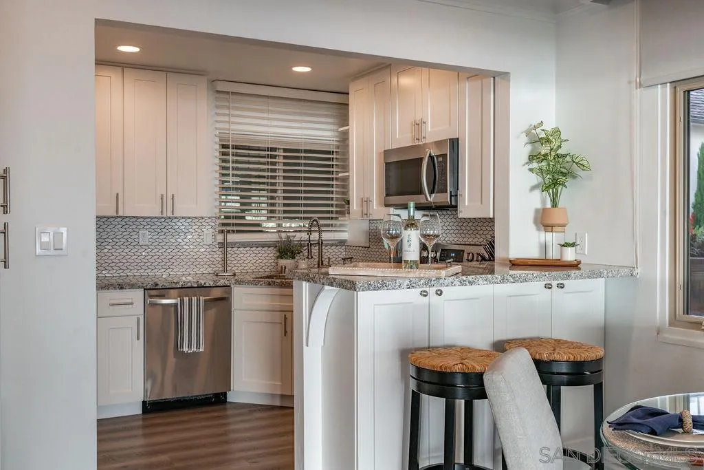 6529 Neptune Place La Jolla, CA 92037 - Photo 9 of 24 a kitchen with stainless steel appliances granite countertop a sink stove and refrigerator