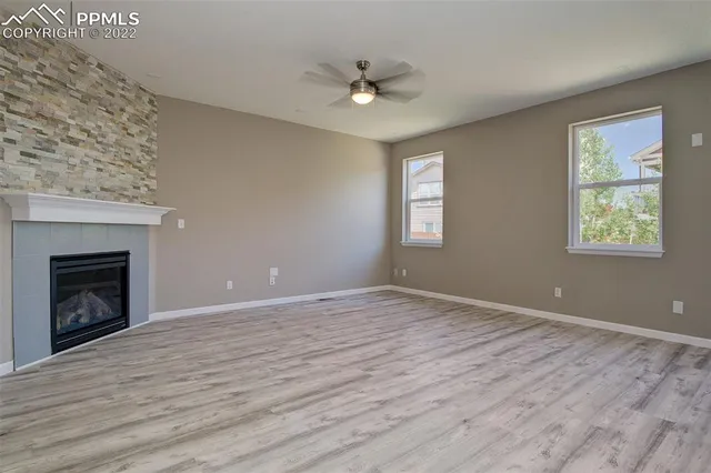 a view of an empty room with a window and fireplace