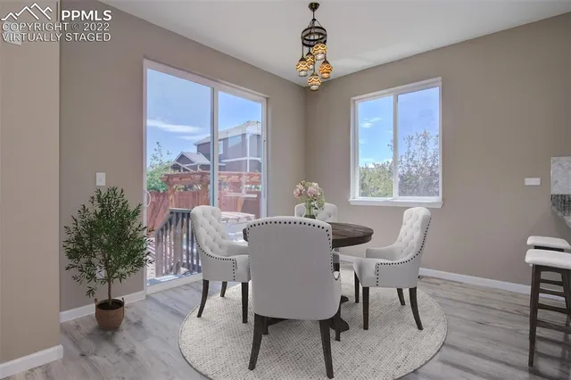 a dining room with furniture potted plants and wooden floor