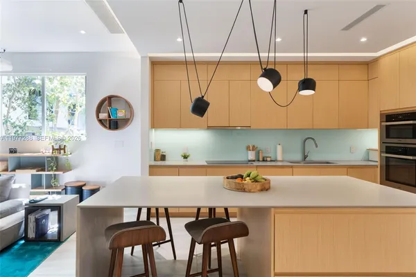 a kitchen with stainless steel appliances granite countertop a sink a stove and a wooden floors