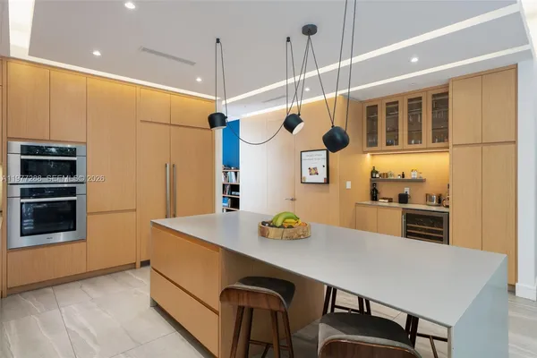 a kitchen with stainless steel appliances a dining table chairs and stove top oven