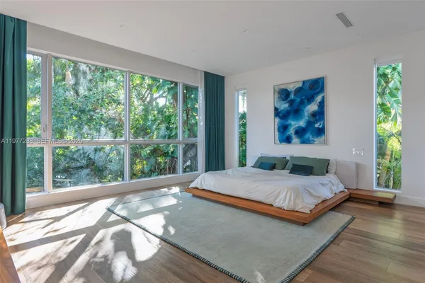 a bedroom with a large bed and a large window
