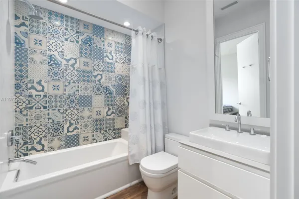 a bathroom with a bathtub toilet sink vanity and shower