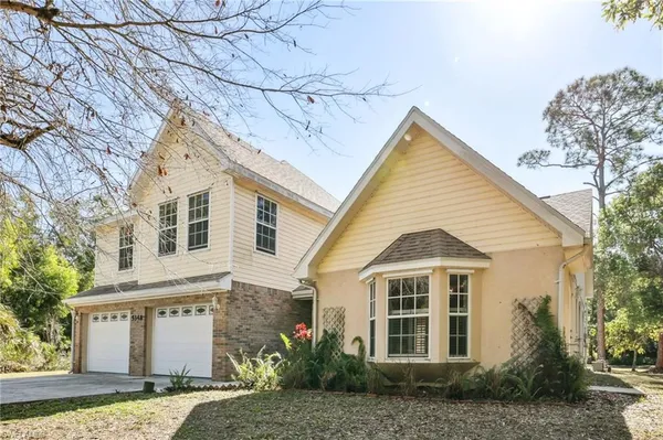 a view of a white house next to a yard