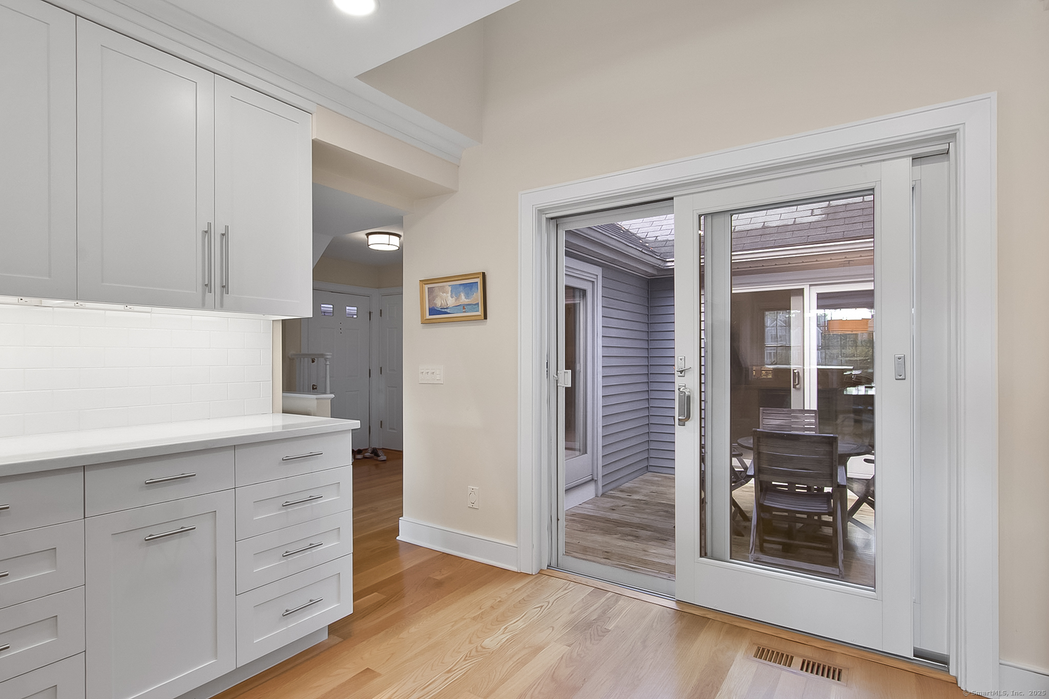 20 Wilton Crest, Unit 20 Wilton, CT 06897 - Photo 27 of 40 a kitchen with white cabinets and wooden floor