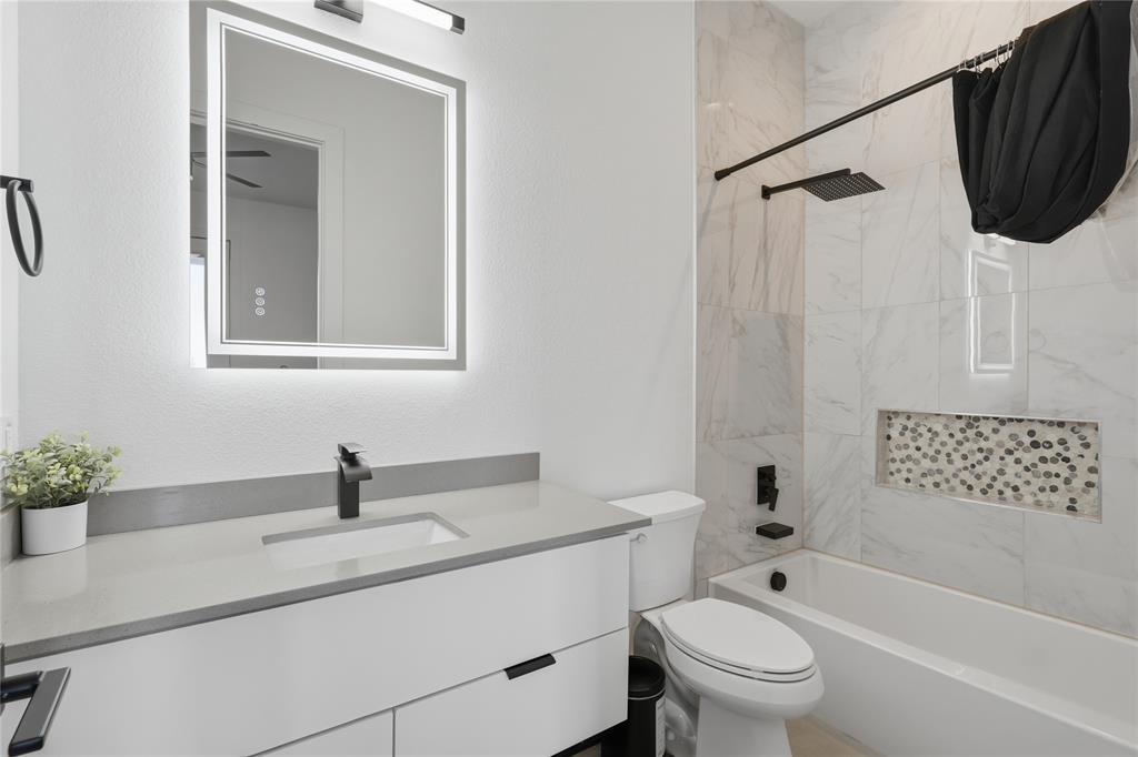 3316 Nomas Street Dallas, TX 75212 - Photo 18 of 27 a bathroom with a sink toilet a mirror a vanity and shower