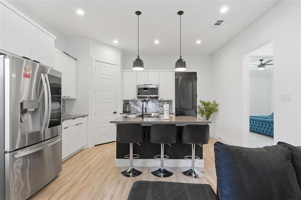 3316 Nomas Street Dallas, TX 75212 - Photo 10 of 27 a kitchen with kitchen island a dining table chairs stainless steel appliances and cabinets
