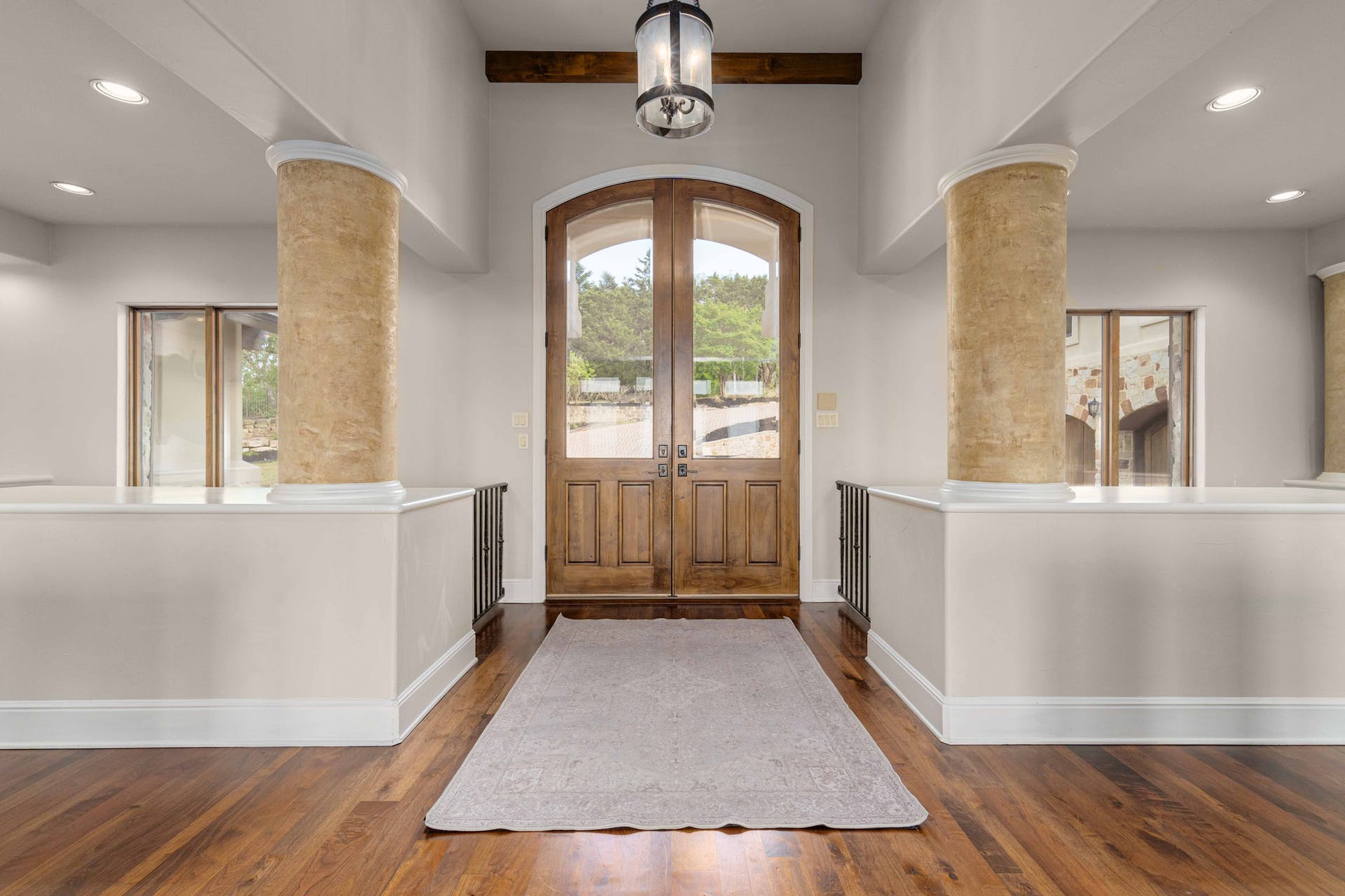 9104 Atwater Cove Austin, TX 78733 - Photo 15 of 36 Entrance foyer featuring recessed lighting, french doors, dark wood-style floors, arched walkways, and decorative columns
