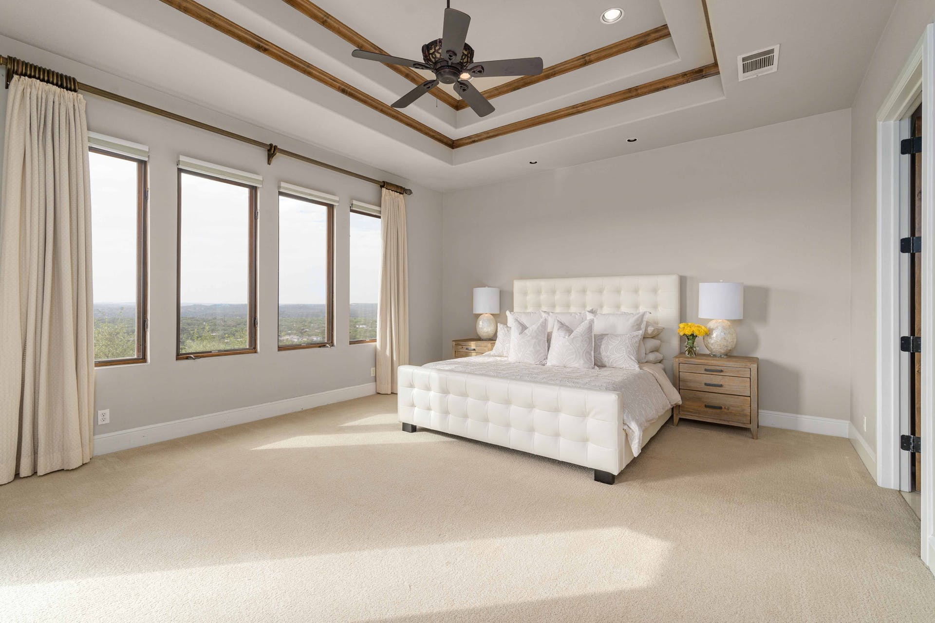 9104 Atwater Cove Austin, TX 78733 - Photo 16 of 36 Carpeted bedroom featuring multiple windows, ceiling fan, a tray ceiling, and recessed lighting