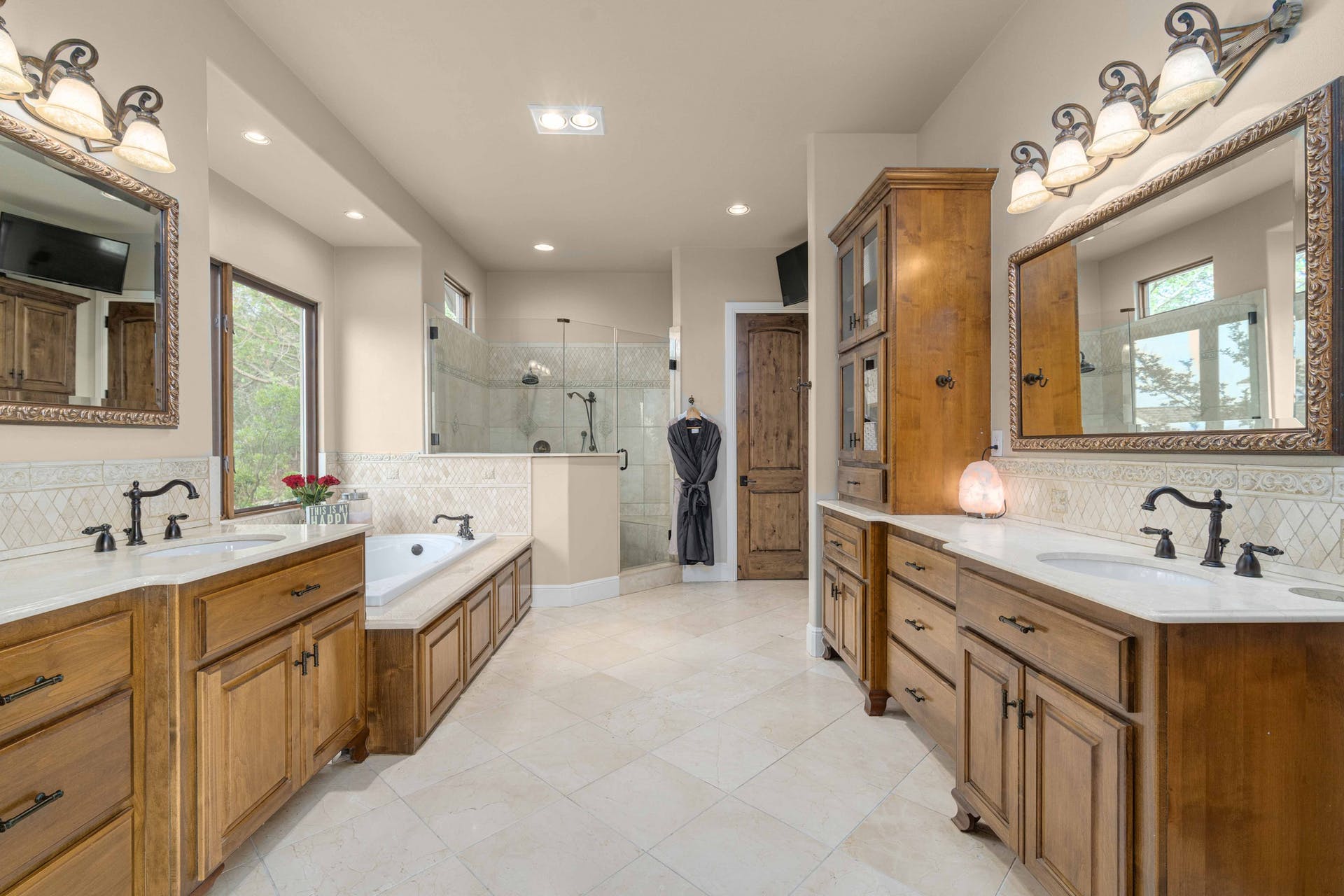 9104 Atwater Cove Austin, TX 78733 - Photo 18 of 36 Bathroom featuring decorative backsplash, two vanities, a garden tub, a shower stall, and light tile patterned flooring