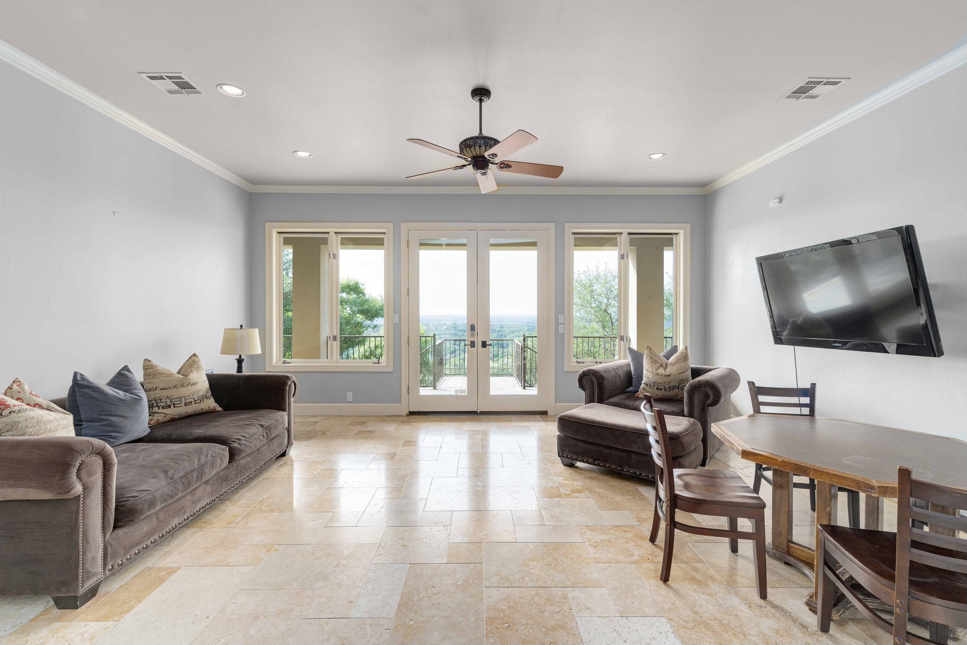 9104 Atwater Cove Austin, TX 78733 - Photo 21 of 36 Living room with french doors, recessed lighting, ornamental molding, a ceiling fan, and stone tile floors