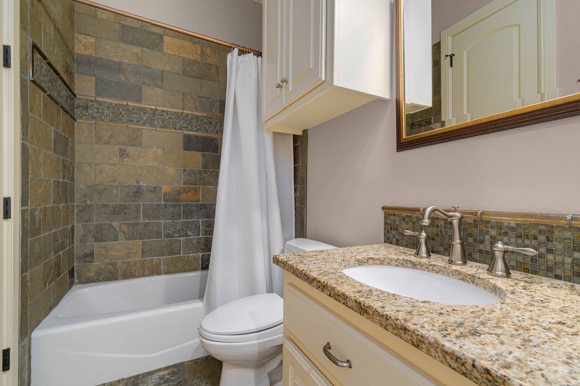 9104 Atwater Cove Austin, TX 78733 - Photo 28 of 36 Bathroom with shower / bath combo with shower curtain, vanity, and backsplash