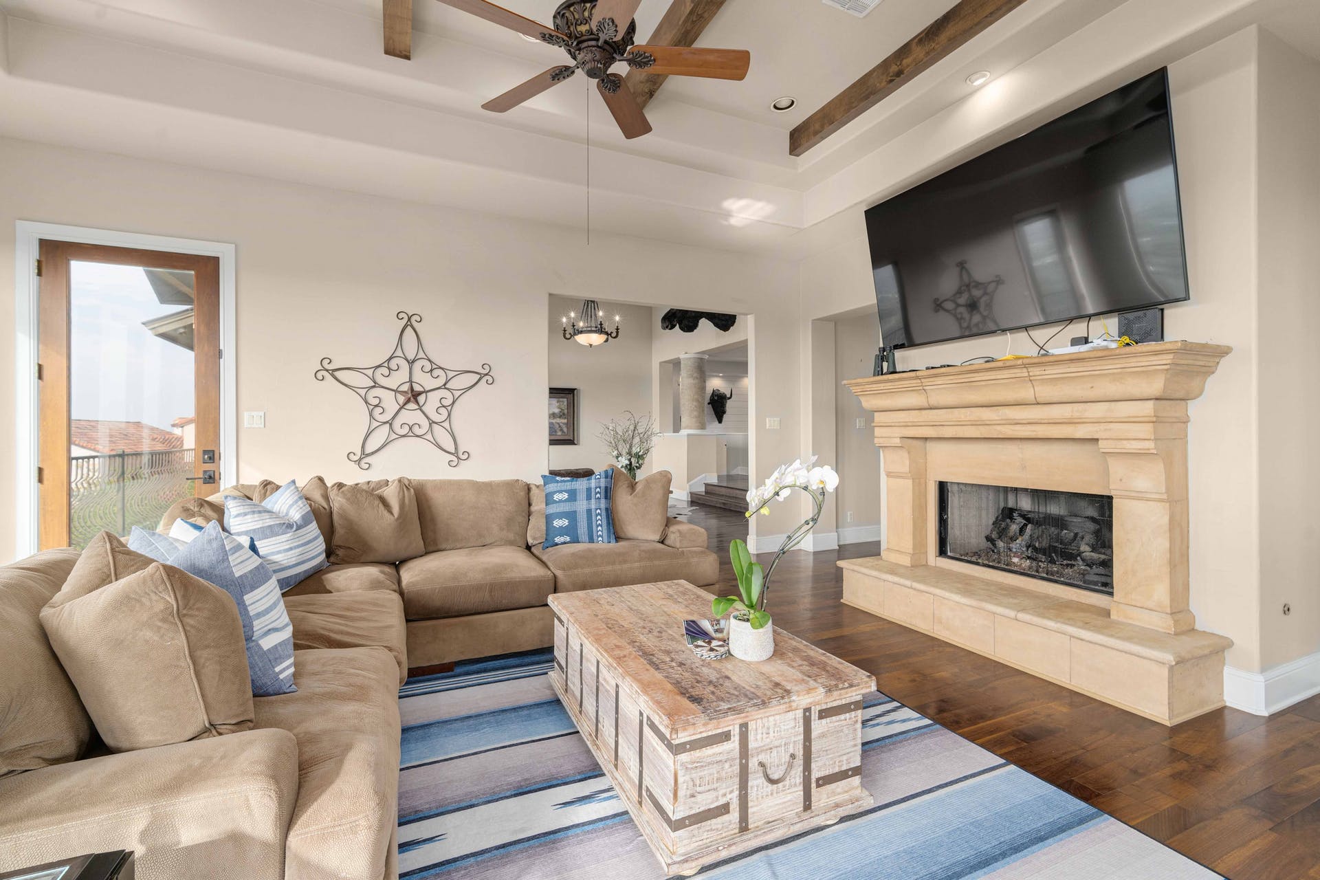 9104 Atwater Cove Austin, TX 78733 - Photo 5 of 36 Living area featuring a fireplace with raised hearth, wood finished floors, a tray ceiling, ceiling fan, and recessed lighting