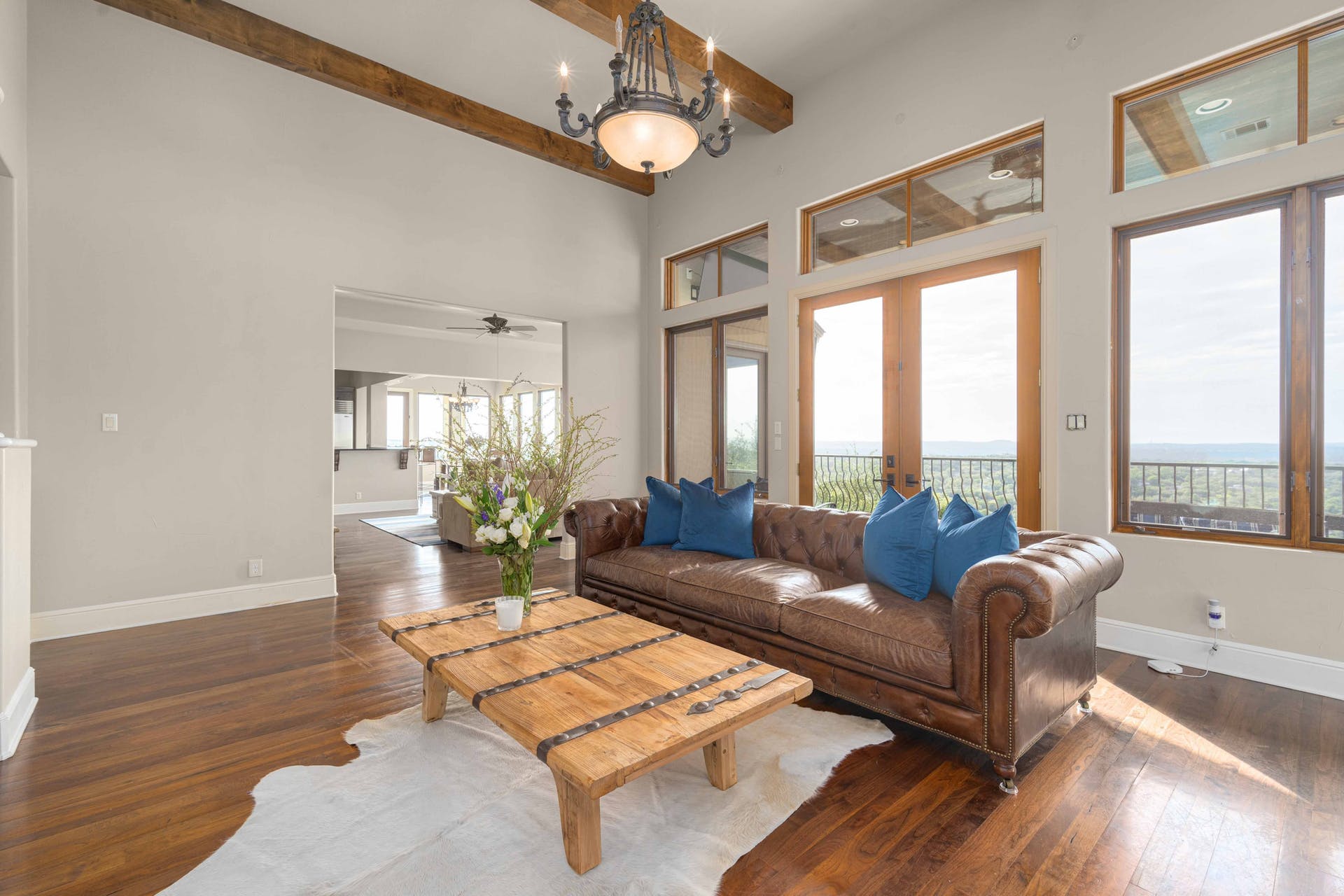 9104 Atwater Cove Austin, TX 78733 - Photo 6 of 36 Living room featuring beam ceiling, dark wood finished floors, a towering ceiling, and a ceiling fan