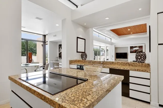 a dining room with furniture a chandelier and glass door