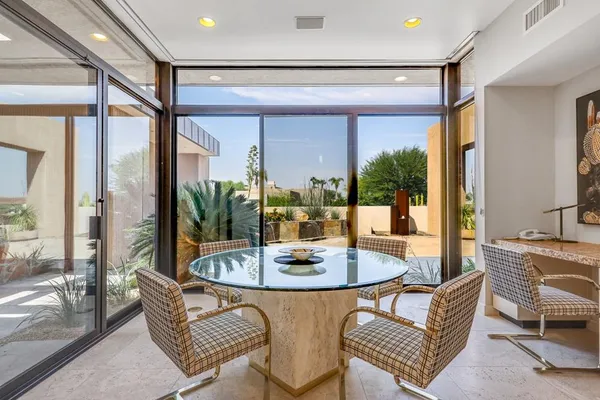 a dining room with furniture large windows and a chandelier