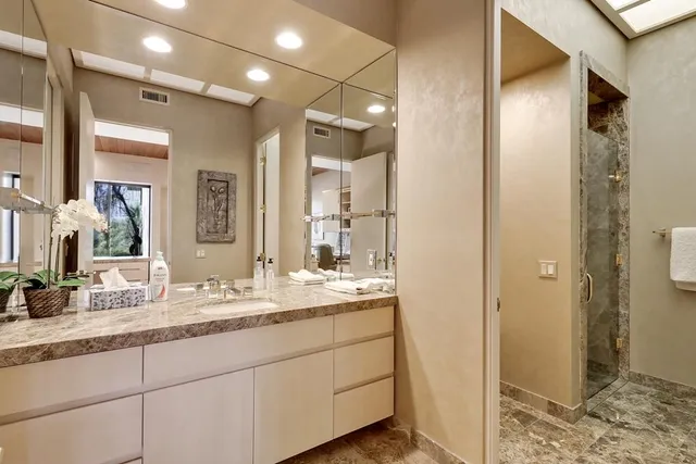 a bathroom with a granite countertop sink mirror toilet and bathtub