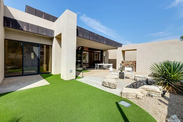 a view of a house with swimming pool and sitting area