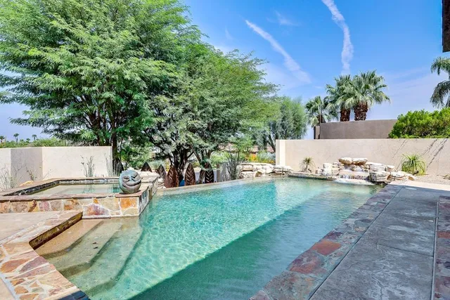 a view of a patio with table and chairs potted plants and palm tree