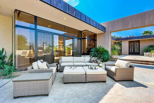 a living room with lots of white furniture and chandelier