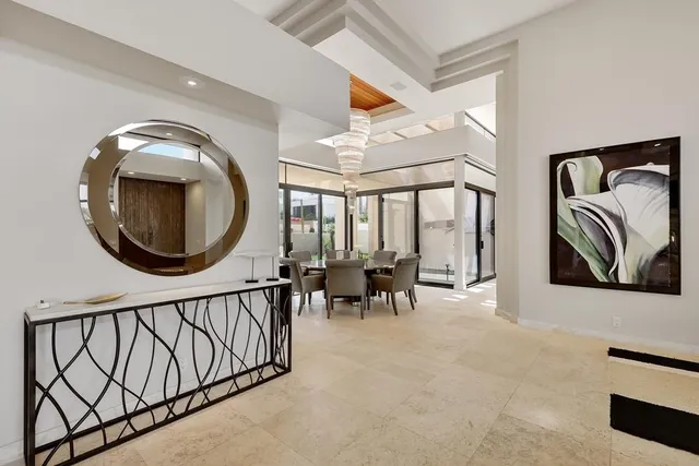 a living room with lots of white furniture and a chandelier