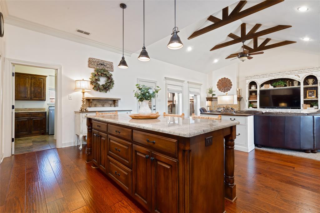 266 Weatherby Street Tuscola, TX 79562 - Photo 10 of 29 Kitchen featuring pendant lighting, light stone countertops, dark wood-type flooring, a center island, and lofted ceiling