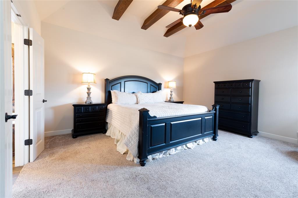 266 Weatherby Street Tuscola, TX 79562 - Photo 11 of 29 Bedroom with light colored carpet, a ceiling fan, and vaulted ceiling with beams