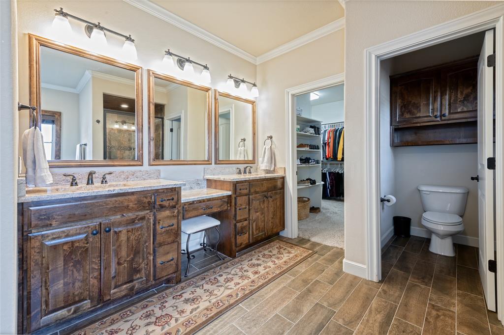 266 Weatherby Street Tuscola, TX 79562 - Photo 14 of 29 Bathroom featuring vanity, a spacious closet, wood finish floors, and ornamental molding