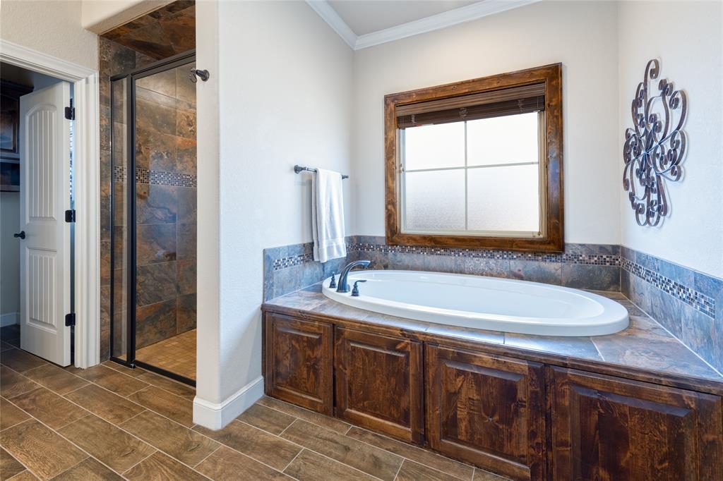 266 Weatherby Street Tuscola, TX 79562 - Photo 15 of 29 Bathroom with a stall shower, ornamental molding, a bath, and wood tiled floors
